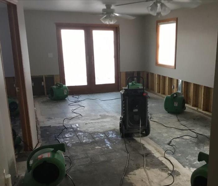 wet carpet removed and equipment drying living room floor and wall that got wet