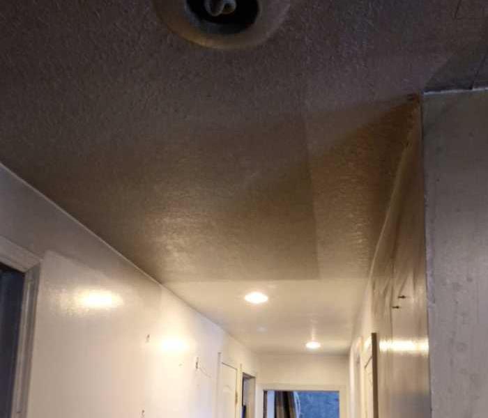 soot on walls and ceiling in hallway from small fire that caught inside home
